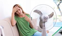 Lady using fan on a very hot day
