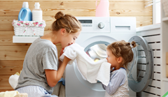 Mother  and young daughter smelling fresh laundry